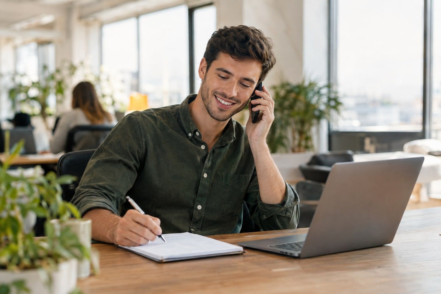 Sales rep following up with a new lead by phone at his desk